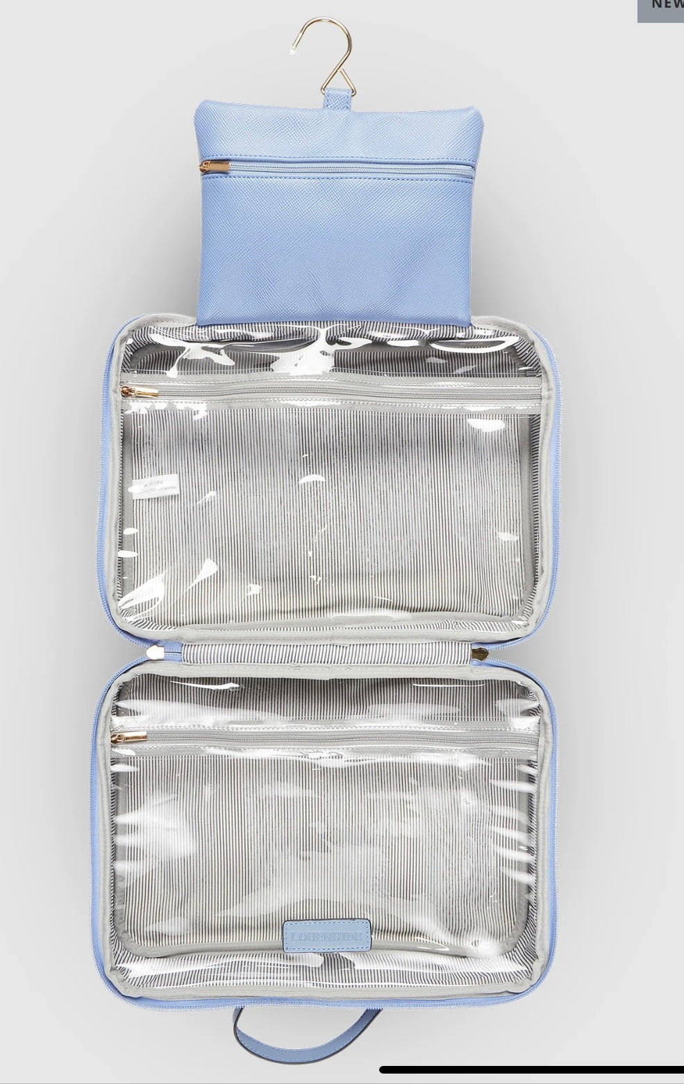 The Emma and Baby Audrey Cosmetic Bags, included in the set of two, feature a light blue hanging design that transforms into a stylish travel cosmetic case. A gold hook at the top provides convenience, while opening the bag reveals two zippered, transparent compartments lined with a chic gray and white striped interior. These spacious sections keep your beauty essentials neatly organized during travel.