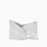 A shiny, metallic silver clutch purse, named the Overlap Hammered Cuff, is photographed against a plain white background. The purse showcases a distinctive crumpled design reminiscent of its namesake and features a zipper closure at the top center. Its reflective surface enhances its modern, futuristic aesthetic.