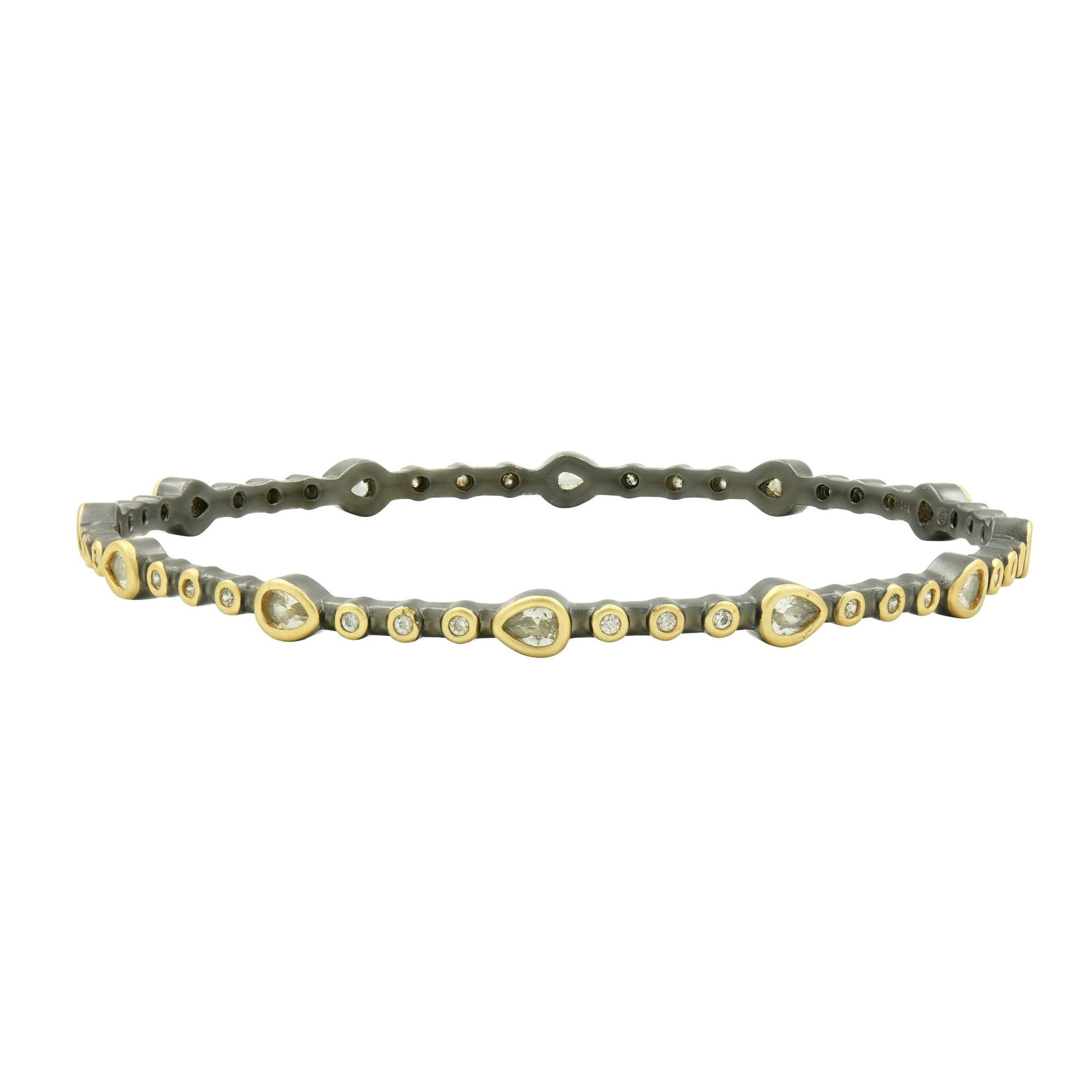 The Teardrop Station Hinge Bangle is a sleek and stylish bracelet, showcasing teardrop-shaped gemstones paired with evenly spaced small round gems along its metallic band. This elegant piece blends gold and silver tones seamlessly, with the teardrop stones beautifully set in gold, making it a delicate and sophisticated addition to any stackable jewelry collection.