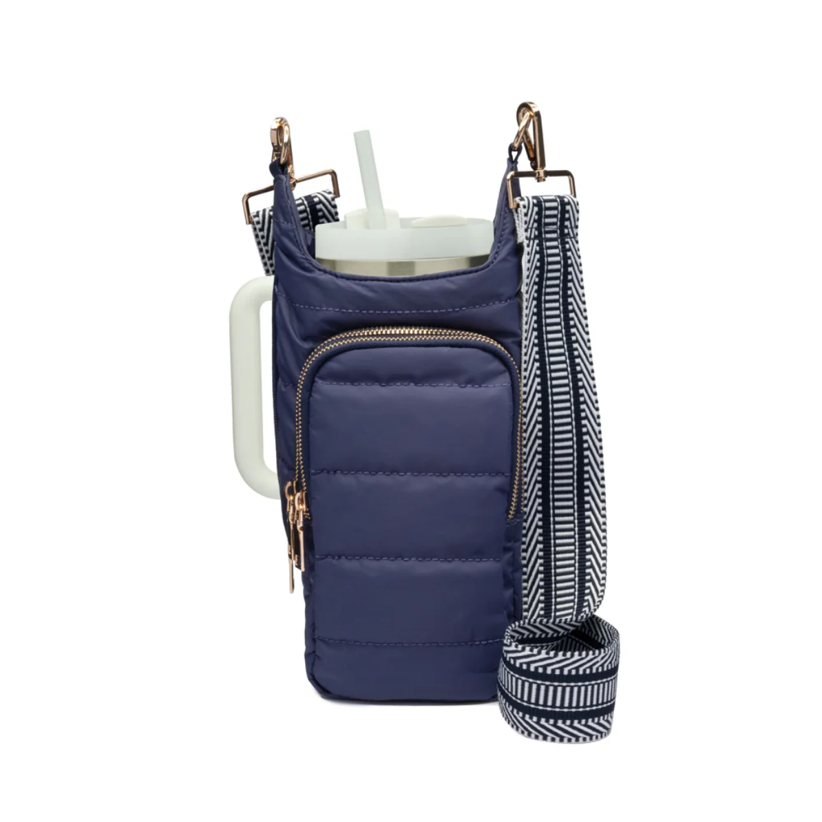 The HydroBag Handle, crafted from dark blue quilted fabric, features a front zippered pocket that elegantly cradles a white tumbler with an elastic straw holder. Beside it hangs a detachable strap in a black and white chevron pattern. The structured design and gold-tone hardware enhance its charm.