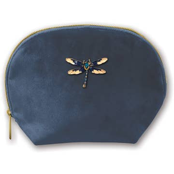 The Clamshell Bag, made from soft blue velvet with a rounded top, features a golden zipper and an embroidered dragonfly motif with metallic blue and gold wings.