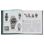 An open copy of *The Book of Rolex* reveals pages featuring images and descriptions of Rolex watches. The left page spotlights various luxury wristwatches, with a notable centerpiece showcasing a striking piece with a metal band. On the right, smaller watch images are accompanied by text paragraphs, all encased within a sleek black cover.