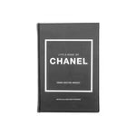 Black hardcover edition of the "Little Book of Chanel" by Emma Baxter-Wright, featuring the title and author's name in white text centered within a white border on the front cover. This minimalist design celebrates Coco Chanel's legendary creations, such as the little black dress and cardigan jacket.