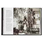 An open copy of "Little Book of Chanel" reveals a black-and-white photograph featuring a woman in a cluttered room adorned with various artifacts, sculptures, and decorative items while wearing what appears to be a Chanel cardigan jacket. The page opposite to the image showcases text in column format, likely connected to the photograph or its subject matter.