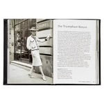 A black-and-white photo captures a fashionably dressed person in a hat and two-piece suit, confidently pointing to a window display on the city sidewalk. The opposite page features "The Trademark Muses." One can almost sense the elegant confidence influenced by Coco Chanel that is captured so well in the "Little Book of Chanel.
