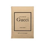 The "Little Book of Gucci" by Karen Homer, available in beige hardcover, captures the essence of Italian fashion. Emphasizing a minimalist design typical of luxury brands, the cover features the book's title and author's name printed in black and centered.