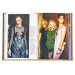 An open copy of "Little Book of Gucci" showcases two pages. The left page exhibits a model in a sheer black dress with intricate patterns, evoking the essence of Italian fashion. The right side displays three women adorned in elegant evening gowns from luxury brands, elegantly posing together at an event, with soft lighting accentuating their ensembles.
