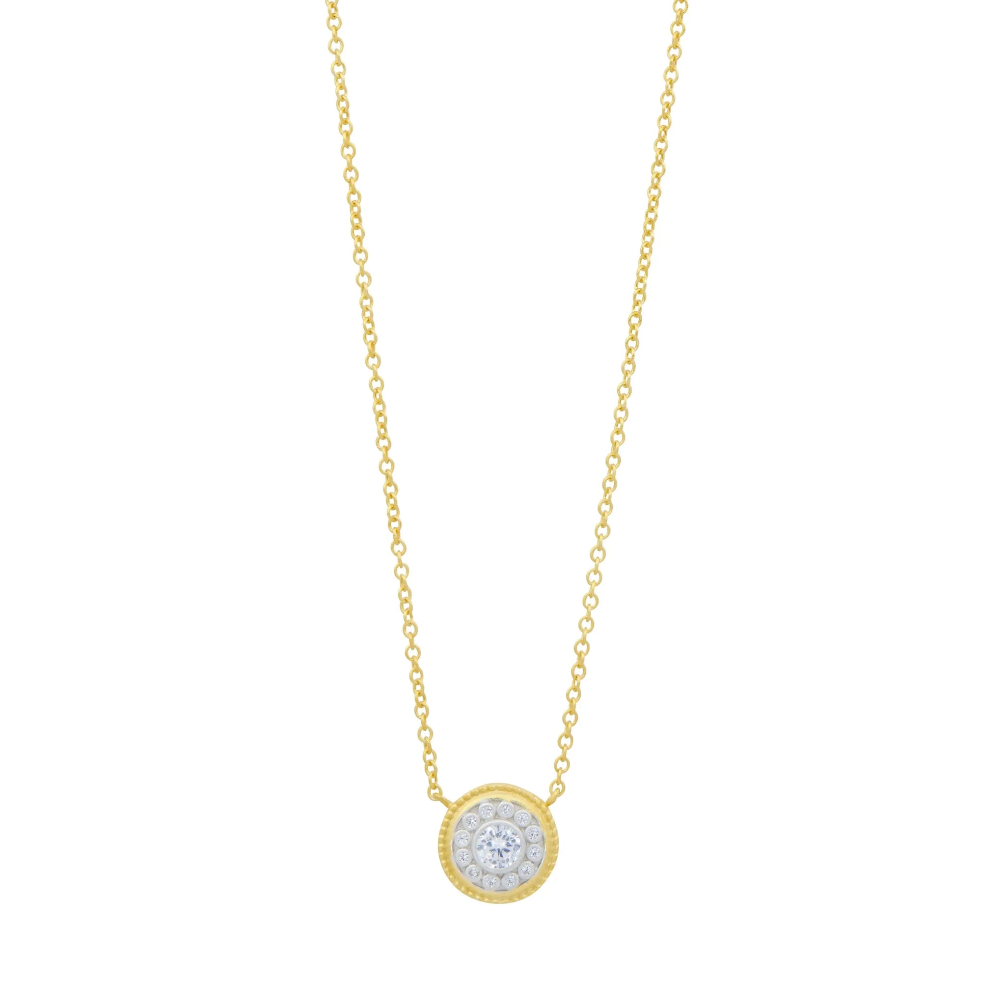 The Nautical Button Necklace features a 14K gold chain with a circular pendant, highlighted by a central white gemstone surrounded by sparkling cubic zirconia, offering a radiant and elegant appeal.