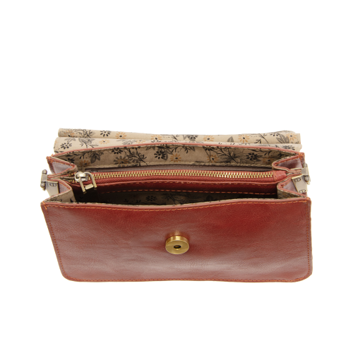 Aria Ring Bag - Fall/Winter in open brown vegan leather, featuring a gold button clasp, displayed against a white background. The interior showcases multiple compartments with a zippered pocket and is lined in beige and black floral-patterned fabric.