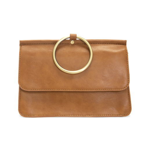 Introducing the Aria Ring Bag - Fall/Winter, a sleek tan vegan leather clutch boasting a large circular gold handle at the top. The bag presents a smooth texture and rectangular shape, complete with a flap closure. The centrally positioned gold handle on the flap adds a modern touch to this effortlessly chic bracelet bag design.