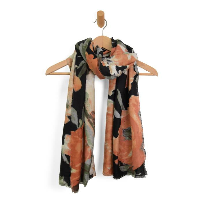 A Midweight Patterned Scarf with a cheetah flair hangs on a wooden hanger, featuring large orange flowers and green leaves against a black background. The soft fabric and slightly fringed edges enhance its wild elegance.