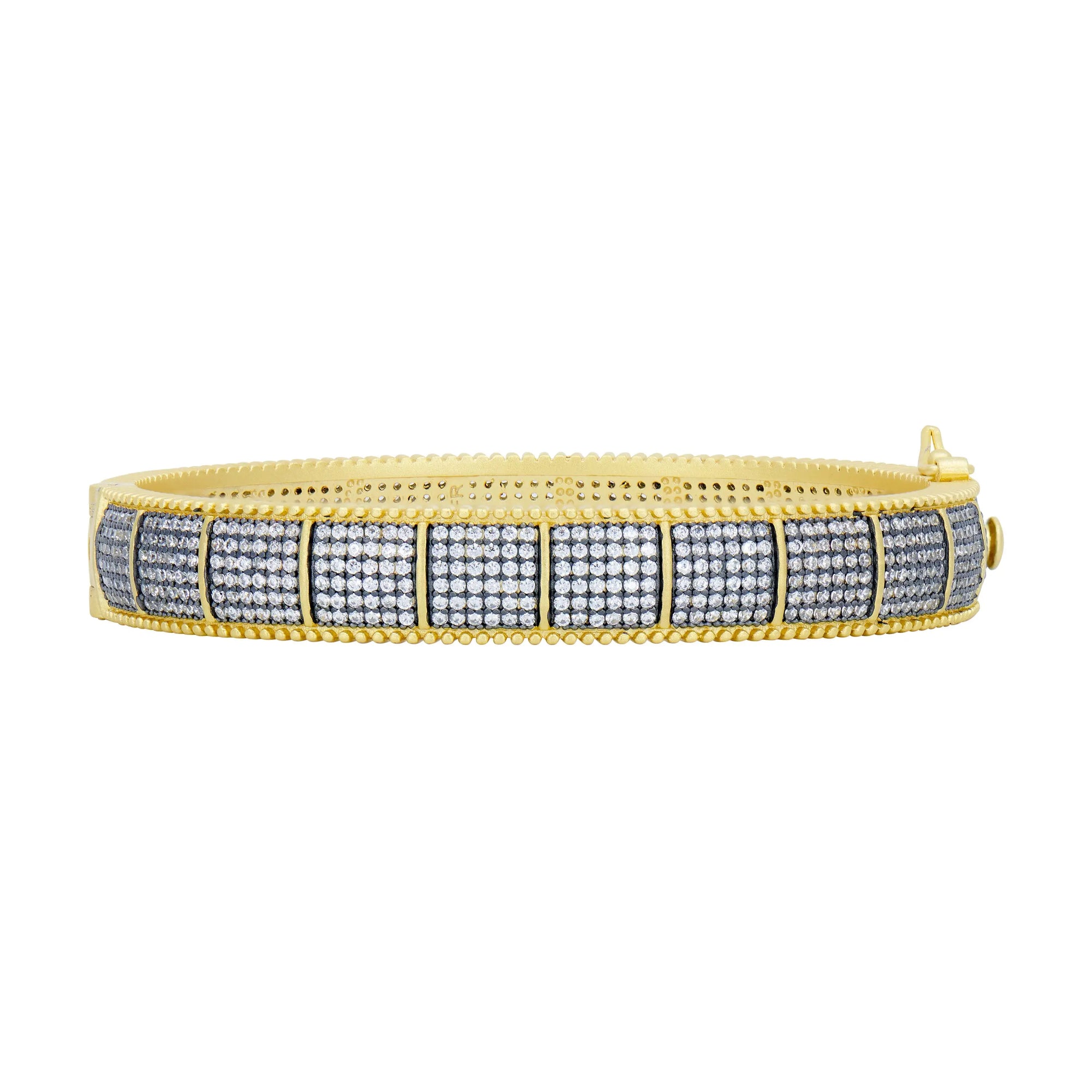 Introducing the Industrial Finish Cobblestone Statement Hinge Bracelet, a stunning gold bangle adorned with a checkered pattern of sparkling cubic zirconia stones. This exquisite design is bordered by a textured gold edge and boasts an elegant two-tone finish. The visible clasp enhances its sophisticated charm, making it the perfect accessory for any luxurious occasion.