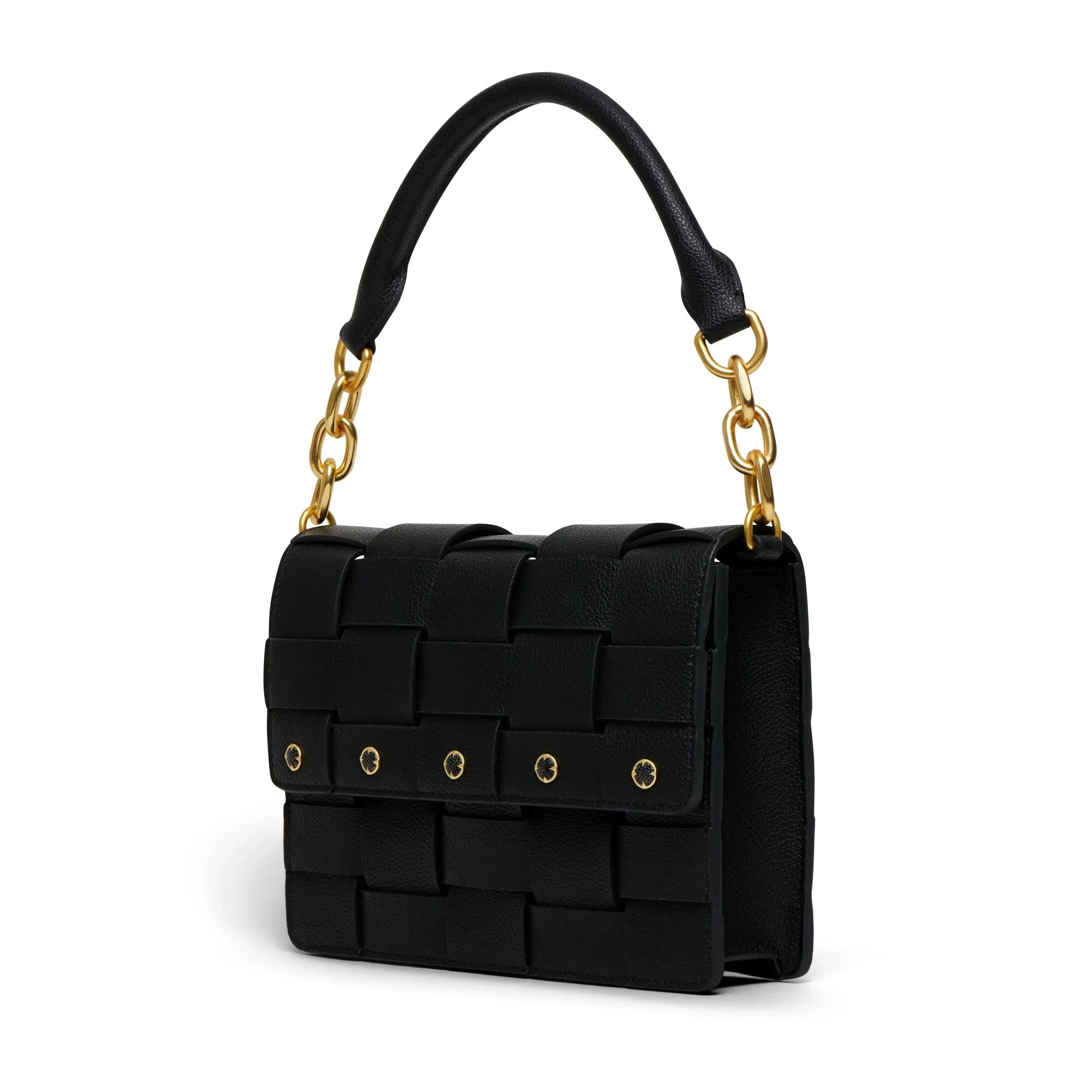 The Bedford Handbag is a black woven handbag made from Italian Nappa leather, showcasing a structured design. It includes a top handle connected by gold chain links and features a flap closure adorned with gold rivet details. The bag has a rectangular shape, and its basket weave pattern provides an enhanced textured appearance against the plain white background.