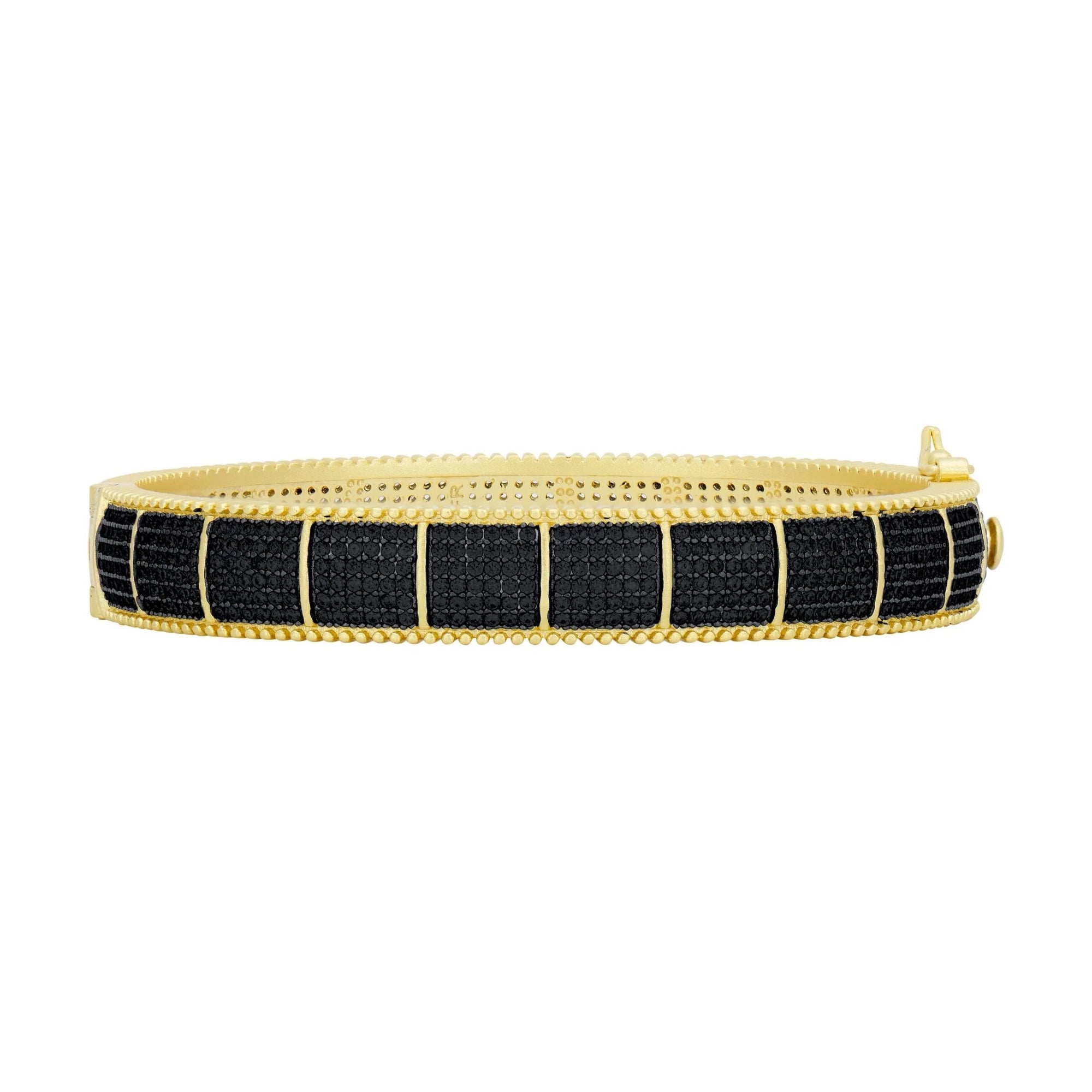 Presenting the Industrial Finish Cobblestone Statement Hinge Bracelet: a stunning piece featuring a black woven design set against a two-tone gold finish, accented with a rectangular pattern. This bracelet boasts textured, beaded edges and an easily noticeable clasp on the right side, combining gold and black for an impressive and elegant appearance.
