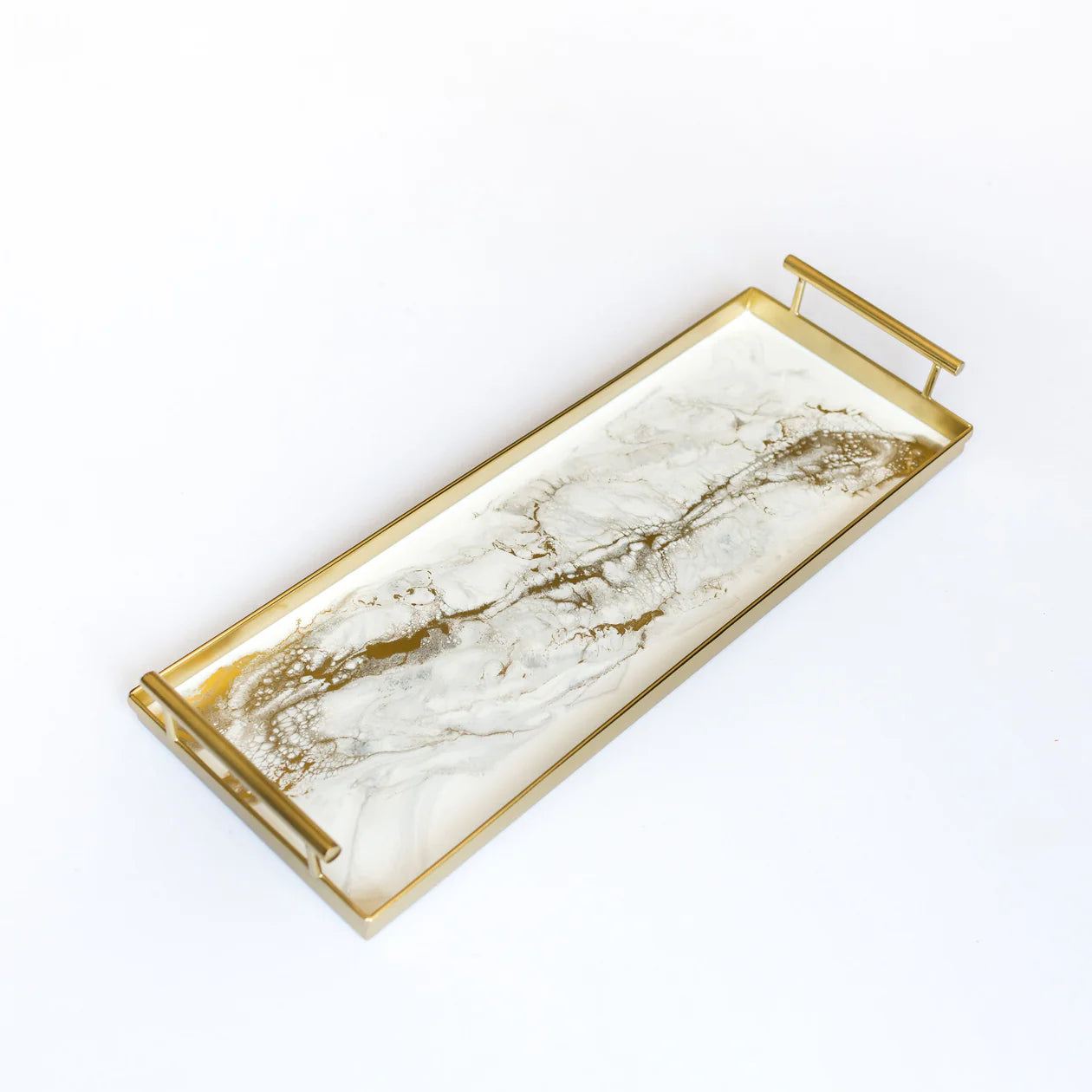 The Resin Gold Rectangle Tray boasts a handcrafted, rectangular design with matte gold handles and a striking golden metal frame. Its base features a white and gray marbled pattern highlighted by metallic gold, delivering an elegant and luxurious appearance. The glossy surface softly reflects light, making it perfect for decorative uses.