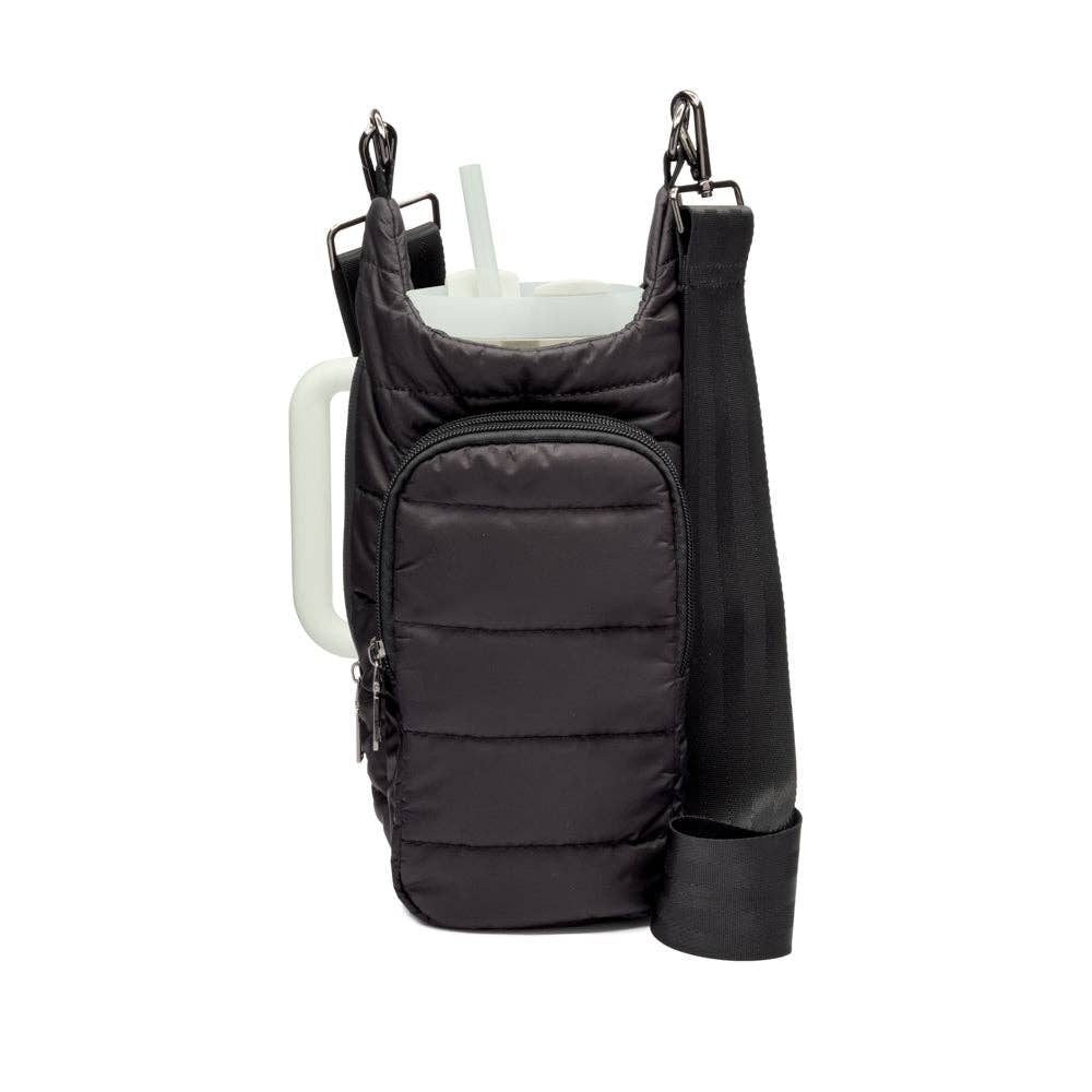A black, padded HydroBag Handle, equipped with an elastic straw holder and a zippered front pocket, secures a white tumbler with a straw. It features silver clasps and adjustable straps for added convenience. The HydroBag Handle ensures easy carrying, while the tumbler's white handle is noticeable on the left side.