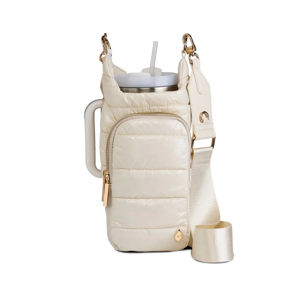 Meet the HydroBag Handle: a quilted, cream crossbody bag for spill-free hydration. It holds your straw tumbler and includes an adjustable strap and side handle. With gold-tone hardware, this stylish accessory is ideal for on-the-go drink carriers.