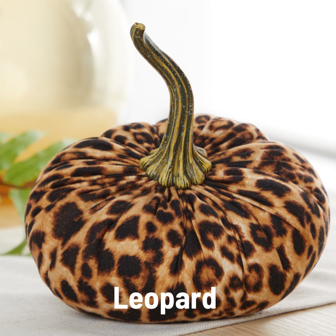 A Handmade Large Velvet Pumpkin, adorned with a leopard print fabric and featuring a striking green stem, embellishes a light-colored surface. This piece of home decor chicly showcases "Leopard" in white text at the bottom center of the image.