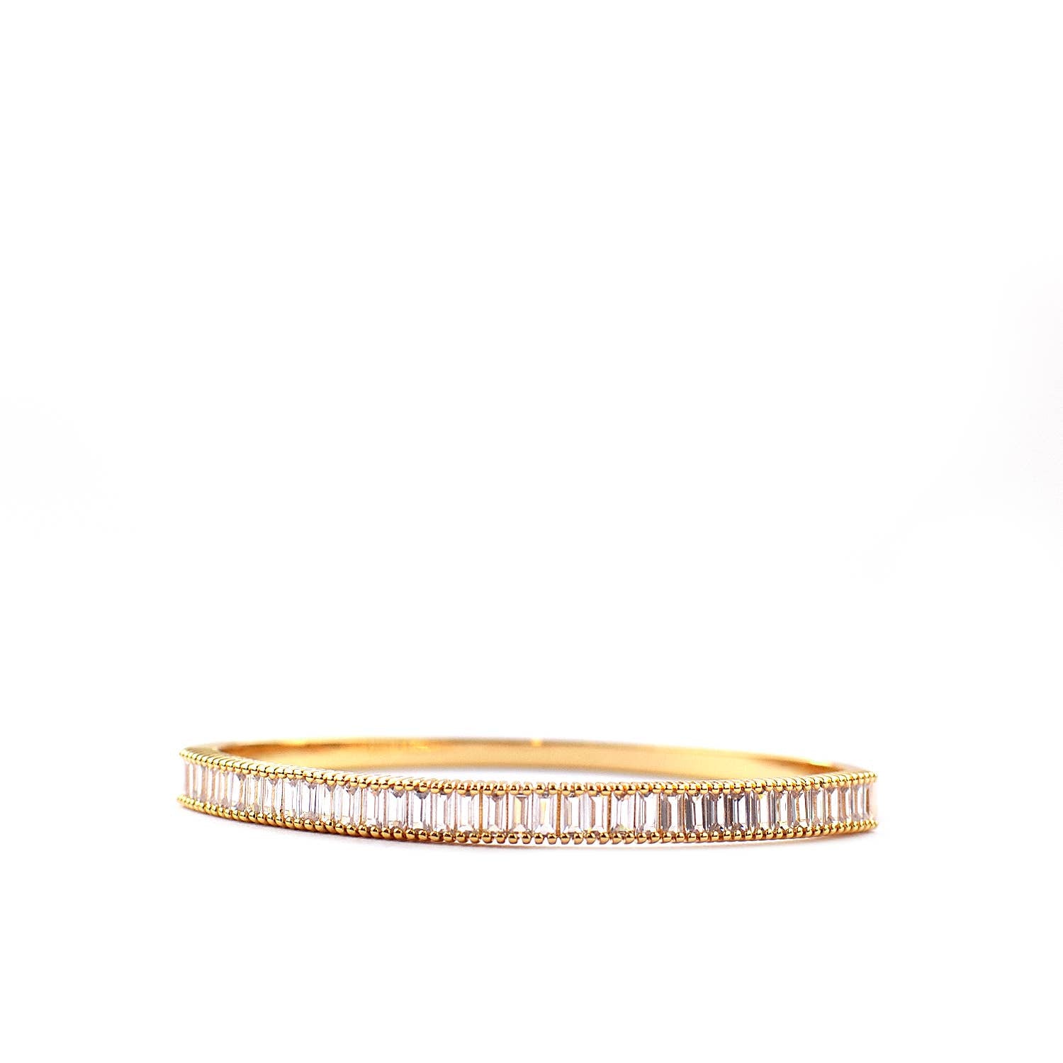 The Sterling Baguette CZ Hinged Bangle is showcased on a white background, featuring intricate edge detailing and uniformly arranged baguette-cut CZ stones that add a luxurious sparkle.