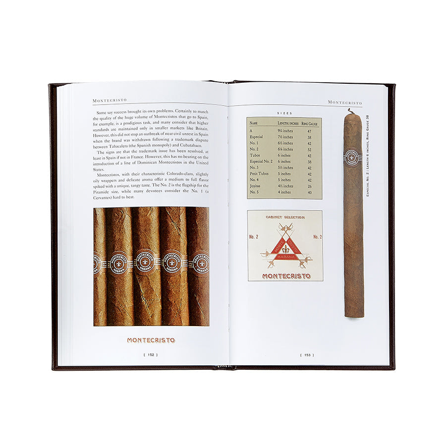 The open book displays The Cigar Companion (Brown Bonded Leather) for cigar enthusiasts. On the left page, there's a description and an image of five handcrafted cigars neatly placed side by side. The right page features a single cigar positioned vertically, alongside a table detailing various sizes and the renowned Montecristo logo, characterized by its red triangle and crossed swords design.