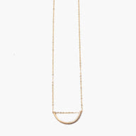 The Arch Necklace, crafted from delicate 14k gold-fill, showcases a minimalist half-circle pendant centered on a fine chain. Its simple yet elegant design highlights ethical fashion ideals and is beautifully displayed against a plain white background.