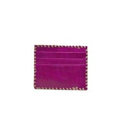 The Ivy Card Holder, a vibrant purple cowhide hair-on leather accessory with elegant beige stitching, gracefully edges the piece. It features multiple card slots and basks in the spotlight of a plain white background, showcasing its handmade charm.