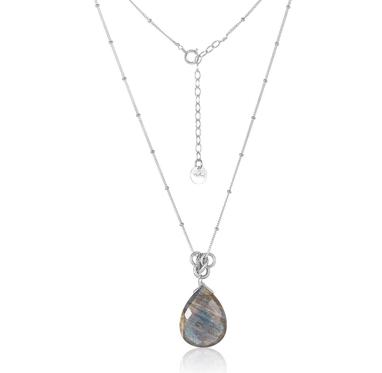 The "Labradorite Pear on Sterling Silver" is an elegant necklace showcasing a pear-shaped labradorite pendant. It features a fine sterling silver ball chain adorned with small bead-like accents and includes an adjustable clasp. The labradorite stone exhibits a gentle play of colors.