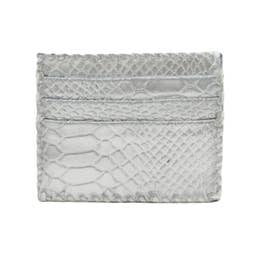 The Ivy Card Holder features a handmade construction with a textured snakeskin pattern in light gray. Its luxurious and sophisticated design is highlighted by intricately detailed scales, while whipstitch detailing enhances the style of its rectangular minimalist form, complete with multiple card slots.