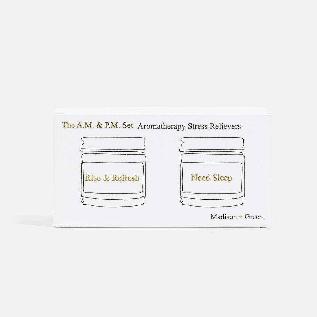 A minimalist white box displays two outlined jars labeled "Rise & Refresh" and "Need Sleep," with the text "A.M. & P.M" Set of Two Aromatherapy Inhalers at the top. The brand name, Madison + Green, is printed in the bottom right corner.