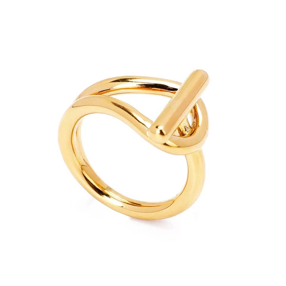 Introducing the Rae Buckle Ring, a modern-style gold ring crafted with tarnish-resistant material. It features a distinctive thick band that elegantly twists into an infinity loop, intersected by a sleek cylindrical bar for a contemporary flair. The ring's polished finish enhances its sophistication by beautifully reflecting light.