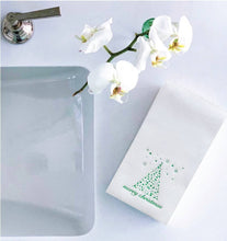 Load image into Gallery viewer, A white bathroom counter with a modern faucet on the left features white orchids and decorative &quot;Merry Christmas&quot; Cloth-Like Guest Towels. The towels showcase green Christmas tree designs with foil-embossed details, adding elegance to the minimalistic setting.
