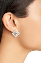 Load image into Gallery viewer, A close-up image showcases a person wearing the Modern Square Spiral Stud Earrings, featuring a spiral design with an antique gold finish. The side profile of the ear highlights the textured surface of these square silver earrings, set against a plain background that emphasizes their minimalistic and elegant style.
