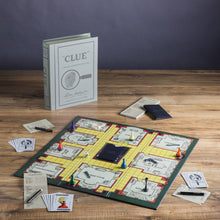 Load image into Gallery viewer, The Clue Vintage Bookshelf Edition board game is elegantly set on a wooden table, showcasing high-quality game components. The board features different rooms with colored pieces, cards, and a notepad. In the background, an upright Vintage Bookshelf Edition box designed to look like a book enhances the atmosphere with its classic board game charm.
