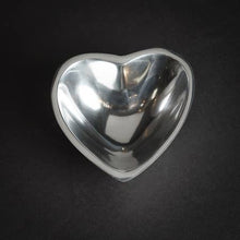 Load image into Gallery viewer, The Heart-shaped Bowl, made of silver aluminum with a reflective finish, showcases a shiny interior and smooth edges, beautifully capturing light. It offers a sleek and modern aesthetic that contrasts elegantly against its dark background.
