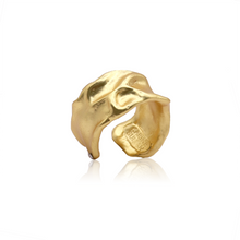 Load image into Gallery viewer, The Crumpled Foil Ring is a striking gold-plated piece with a fluid, abstract design that mimics gentle waves or folds. Its reflective surface highlights its textured allure. This adjustable ring features an engraved interior and its open-ended shape enhances its organic, artistic appeal.
