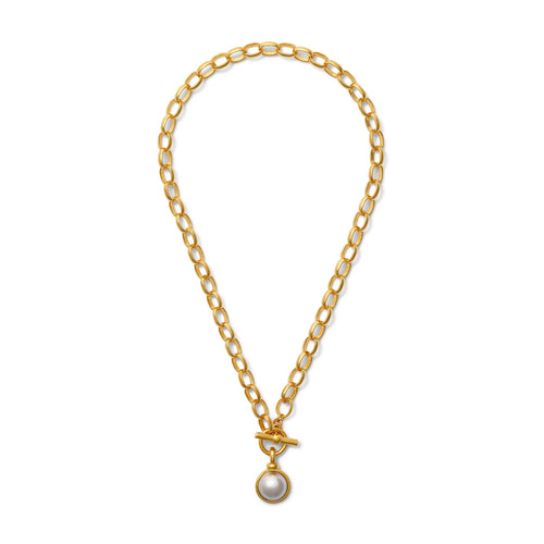 The Jackie Jr. Pendant Necklace is crafted from 14 karat gold with oval links and features a toggle clasp. It showcases a single grey mabe pearl pendant encased in a simple gold setting, exuding an elegant and classic appearance. The chain is elegantly displayed in an oval shape on a white background.