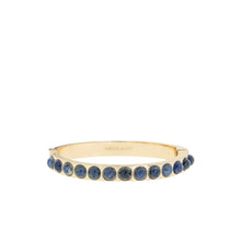 Load image into Gallery viewer, Introducing the Semi Precious Stone Bangle: This contemporary gold hinged bracelet boasts a sophisticated 6 1/4&quot; circumference. It showcases an array of round blue semi-precious gemstones nestled in bezel settings, while its elegantly engraved interior highlights the stunning contrast between the lustrous gold and vibrant stones.
