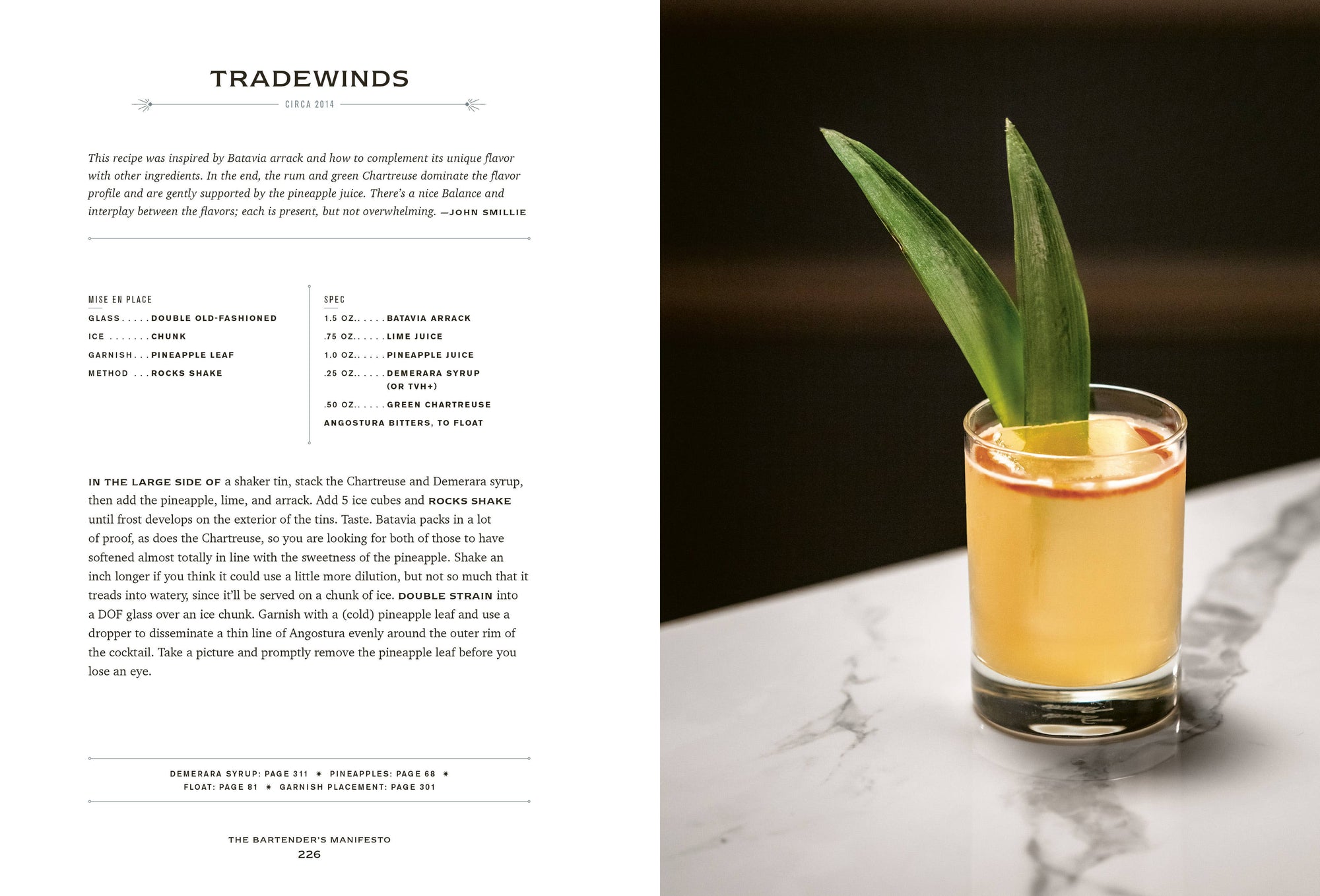 A cocktail glass sits on a marble surface, displaying an orange drink adorned with two long pineapple leaves. To the left, a recipe from "The Bartender's Manifesto" reveals mixologist secrets for crafting perfect cocktails. The ingredients and instructions are presented in a clean, serif font on a white background.