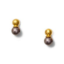 Load image into Gallery viewer, On a white background, the Gold Lady Earrings are showcased. Each piece showcases a shiny gold domed top perched above a larger dark gray pearl-like bead. The minimalist design highlights the striking contrast between the metallic gold and the sleek, reflective gray surfaces.
