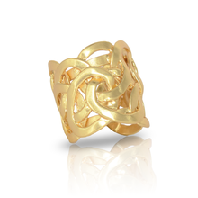 Load image into Gallery viewer, The Juliette Ring, a fashionable gold accessory, features a broad, interwoven knot pattern that highlights its intricate design and polished finish. Elegantly reflecting light, it stands upright on a white surface, with its mirrored reflection enhancing the allure of this exquisite piece.
