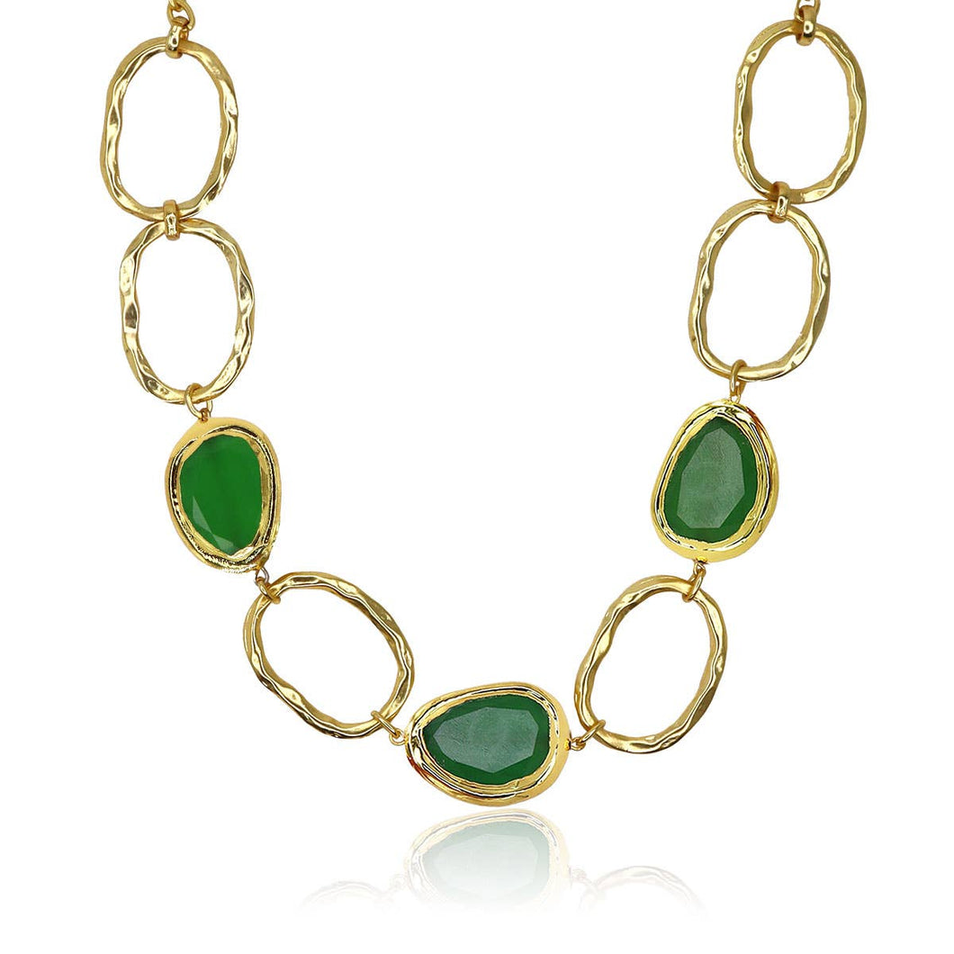 The Vivid Gems Trio Necklace, a true statement piece, features irregular gold chain links adorned with three striking green gemstones framed in gold. Its reflective finish exudes opulence and elegance, making it a standout addition to any jewelry collection against a white background.