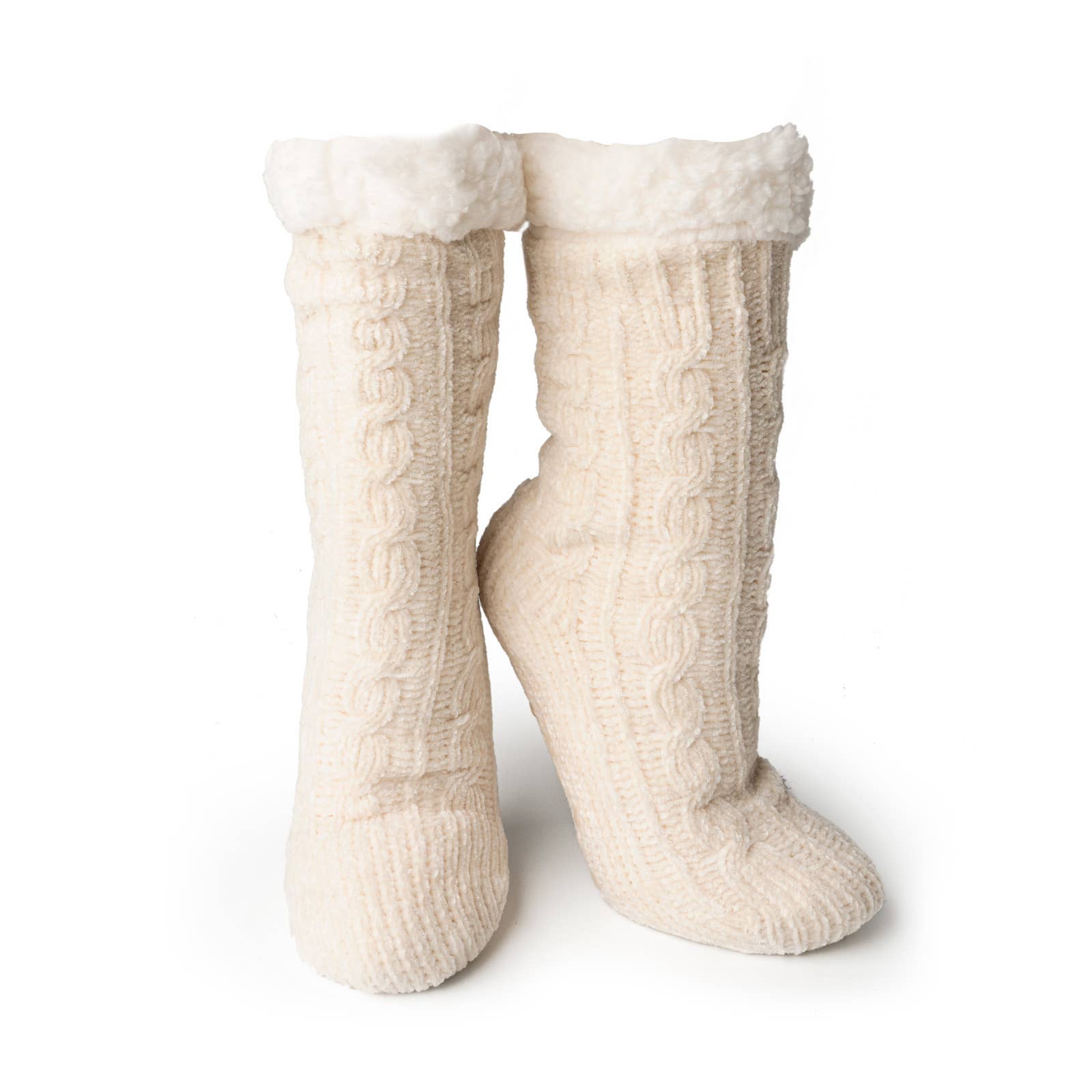 The Beyond Soft Slipper Socks are tall, cream-colored cable-knit slipper socks with a plush, fluffy lining at the top. They feature non-slip soles and stand upright to showcase their intricate knitted pattern and soft texture.