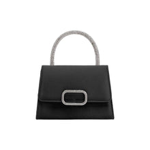 Load image into Gallery viewer, The Sadie Satin Top Handle Bag is a small, elegant, black handbag with a rectangular shape and flap closure, highlighted by a metallic buckle. Its silver crossbody strap adds shimmer and style to its minimalist design, making it both chic and functional.
