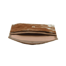 Load image into Gallery viewer, The Diana Clutch - Cowhide Hairon Leather is displayed in a brown and white color scheme. This artisan-crafted wallet includes a flap closure secured with a button snap. Inside, the tan fabric lining unveils a roomy main compartment. The clutch&#39;s unique cowhide pattern and whipstitch detailing highlight its natural elegance.
