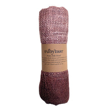 Load image into Gallery viewer, A Wabi Silk Scarf, woven with a textured pattern in pink and burgundy hues, wrapped in brown paper branded &quot;rubyzaar.&quot; Made sustainably on a traditional Thai loom from mulberry silk, it comes with care instructions for handwashing and air drying.
