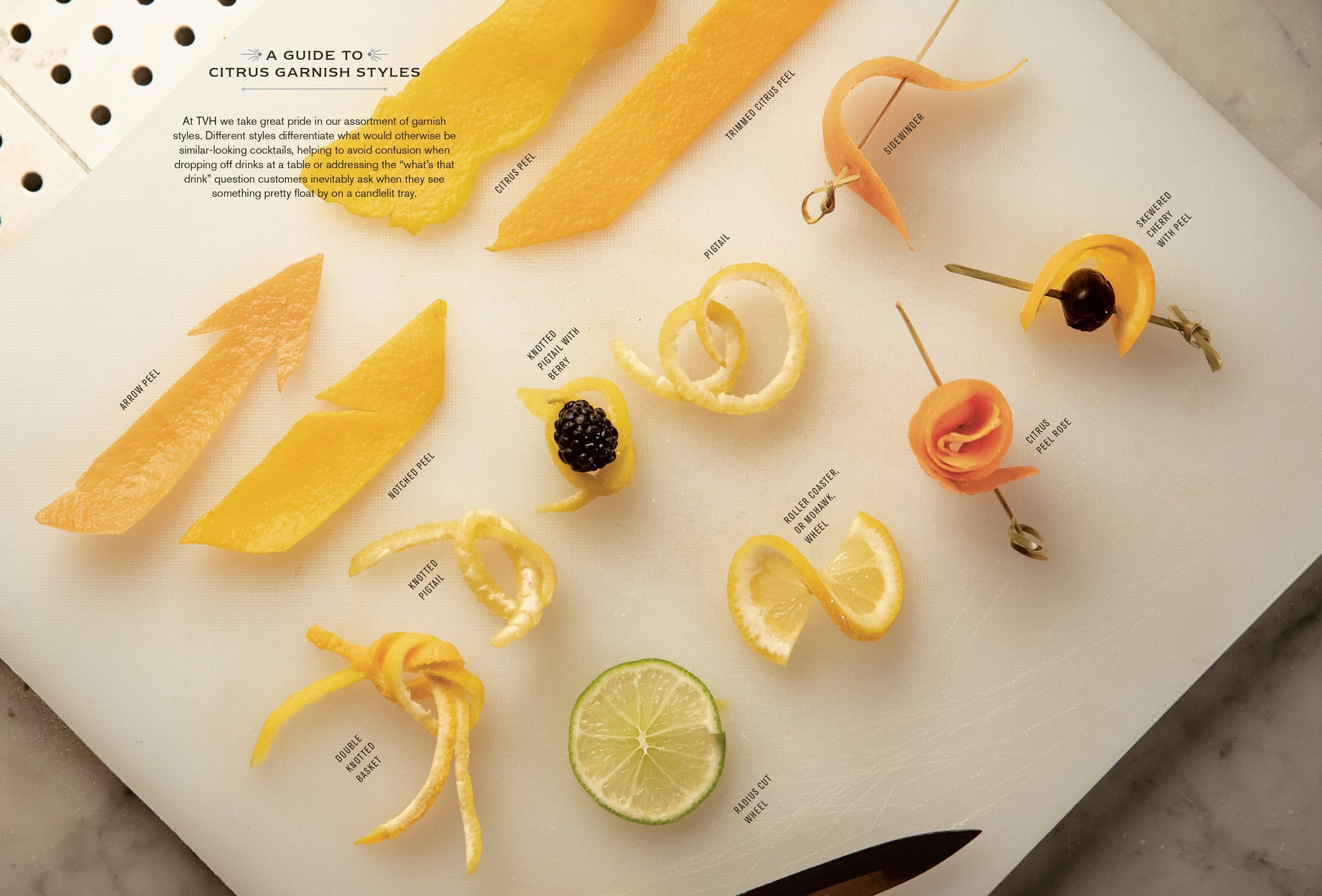 Displayed on a white surface is "The Bartender's Manifesto," featuring a range of citrus garnishes ideal for any mixologist's toolkit. It includes twists, cocktail pick-tied twists, and a lime wheel, with labels indicating styles such as freeform, round twist, crescent twist, floating crescent twist, and express and discard. A small knife can be seen at the bottom.