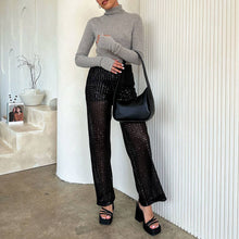 Load image into Gallery viewer, In a stylish, minimal interior with a curved wall and modern decor, someone wears a gray turtleneck, black sequined pants, platform sandals, and holds the Willow Recycled Vegan Shoulder Bag.
