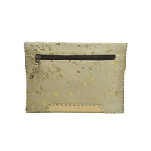 Load image into Gallery viewer, The Diana Clutch - Cowhide Hairon Leather is a rectangular wallet that showcases a tan and gold speckled exterior, complemented by a zippered pocket on the front. Its elegant design features whipstitch detailing along the edges and a smooth beige leather patch at the bottom center. The zipper pull matches in tan, reflecting the overall artisanal craftsmanship.
