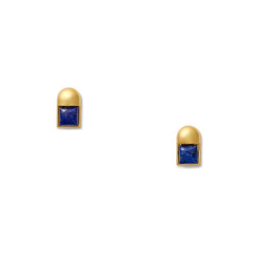 The Baby Cubism Earrings are a pair of sleek, post earrings that showcase square blue gemstones stylishly set in a 14 karat gold frame with rounded tops. Displayed against a plain white background, they feature hypoallergenic silicone backs for added comfort.