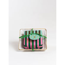 Load image into Gallery viewer, The &quot;Holiday Soap in a Dish&quot; features a square soap adorned with green and pink stripes, elegantly sitting on a white dish with a gold rim. It radiates festive cheer and is accented by a green ribbon tied around it. Atop the soap rests a circular turquoise tag labeled &quot;L&#39;Occitane en Provence.&quot; The set is presented against a simple white background.
